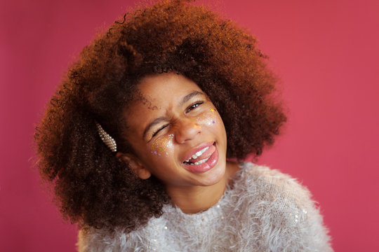 Funny girl with shiny makeup against bright pink background