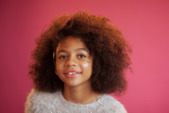Beautiful girl with shiny makeup against bright pink background