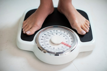 Close Up Of Woman Standing On Bathroom Scales At Home