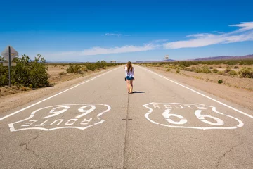 Tuinposter Jonge vrouw die zich op de Route 66-weg in Californische woestijn bevindt. Verenigde Staten © vivoo