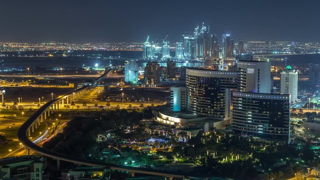 Night view of new modern buildings and lights from roads and metro line with construction in Dubai creek harbor on a background from above Aerial Timelapse, Dubai, United Arab Emirates
