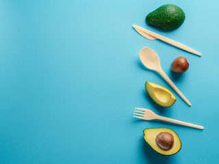 Avocado Seeds Biodegradable Single-Use Cutlery. Bioplastic - Great alternative to plastic disposable cutlery. Minimal concept on blue background. Copy space for text or design