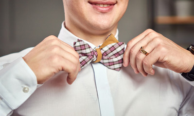businessman putting on  bow tie,man butterfly clothes,groom getting ready in the morning before wedding ceremony