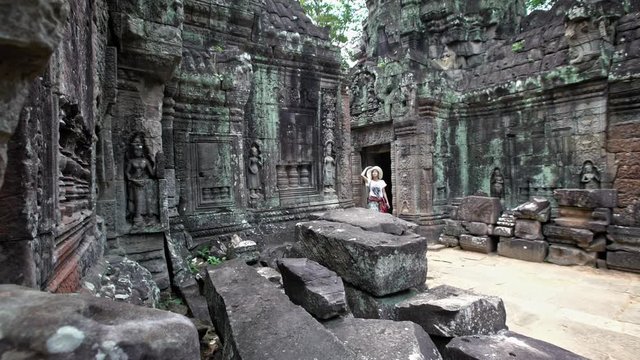 4K, Beautiful asian woman take a walk in ancient Hindu temple of Ta Som. Tourist girl walks alone through the walls of archaeological temples in Siam Reap, historic area of Angkor Thom. Cambodia-Dan