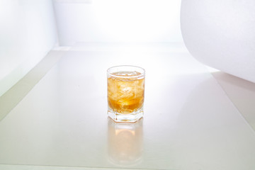 glass of yellow tincture on white background