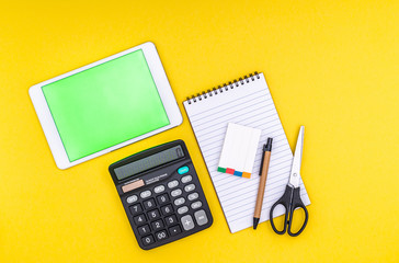 Stationery, tablet with green screen on yellow background