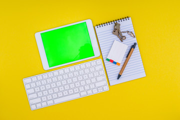 Stationery, tablet with green screen on yellow background