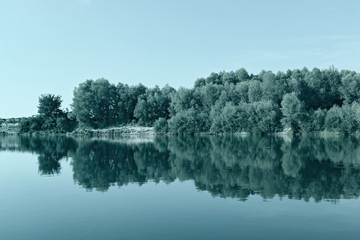 Glass river surface shore hill reflection. Blue sky and water and central beautiful scenic tranquill calm cold stylish dramatic photo