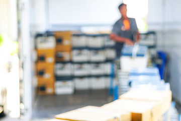 Blur white An employee loaded a cardboard box into a truck. Deliverymen planned separate parcels.