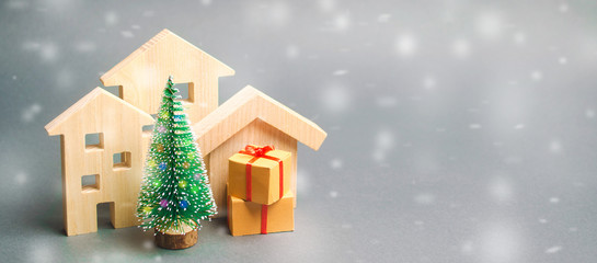 Wooden houses, Christmas tree and gifts. Holiday. Winter vacation. Christmas Sale of Real Estate....