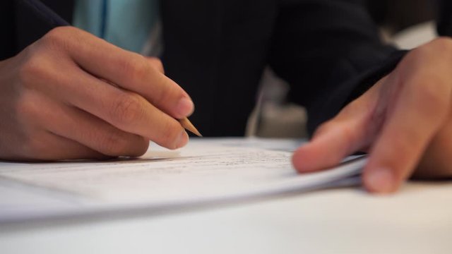 Businessman Manager take notes or signing documents reports papers on paper files in meeting room, modern blur light background, Document report or business management concept