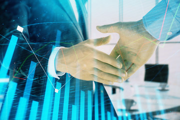 Multi exposure of financial graph on office background with two businessmen handshake. Concept of success in business