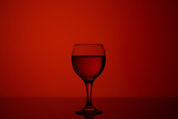 Fototapeta na wymiar champagne glass on red beautiful background on black glass