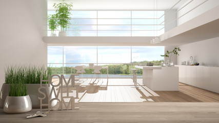 Wooden table, desk or shelf with potted grass plant, house keys and 3D letters home sweet home, over white and wooden kitchen, architecture interior design, copy space background