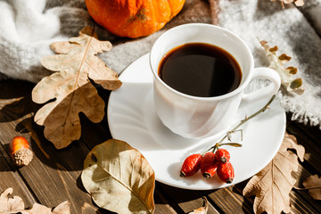 beautiful autumn composition with coffee. autumn leaves and pumpkins on a rustic tree background. the concept of the fall season