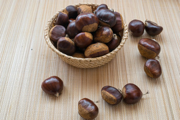 sweet chestnuts in a basket on a wooden table