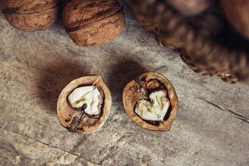 Walnuts in a round wicker basket on a wooden background. Place for your text
