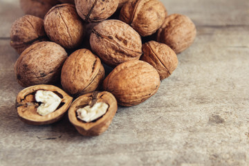Walnuts in a round wicker basket on a wooden background. Place for your text