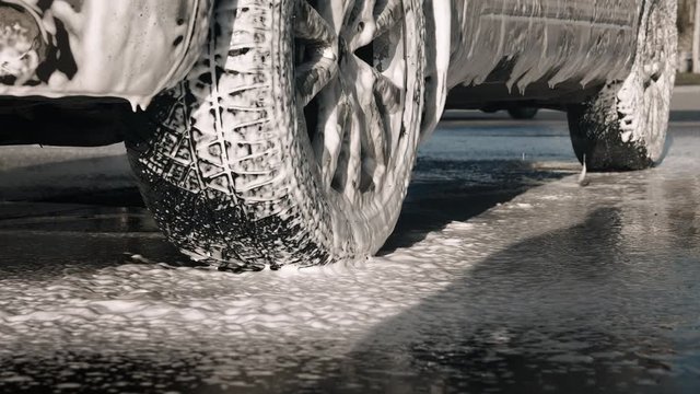 Foam drains from the car. Car wash