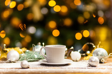 White coffee mug with gold shiny Christmas decorations.