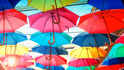 Multicolored rainbow colorful umbrellas hung over street © KAL'VAN