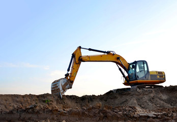 Excavator digs the ground for the foundation and construction of a new building. Road repair, asphalt replacement, renovating a section of a highway, laying or replacement of underground sewer pipes