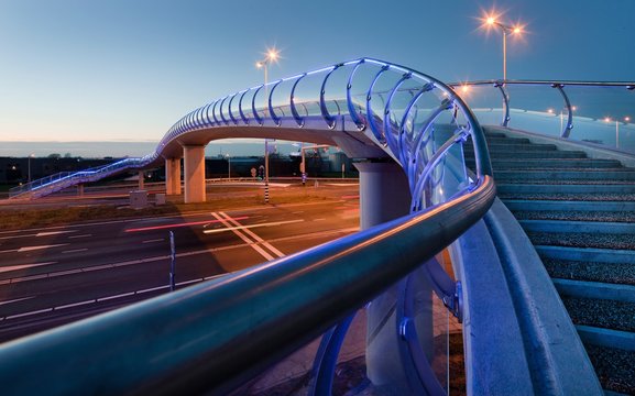Modern Dutch architecture. Glass pedestrian bridge Barendrecht. Stairs. Evening. Twilight