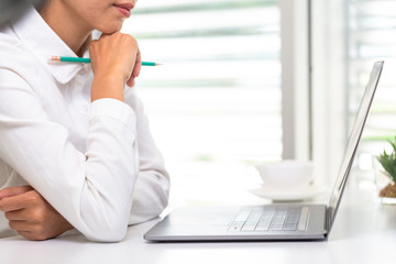 A business person sitting and working in an introspective manner On the table with a laptop....