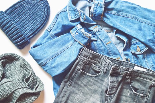 Blue woolen hat, knitted  scarf, denim jacket and trendy jeans. Flat lay photo stylish fashion outfit