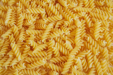 Fusilli pasta as background image. Image texture spiral macaroni. Top view. Copy, empty space for text