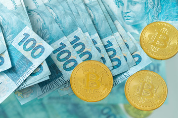 Brazilian money, banknotes 100 reais and virtual currency Bitcoin