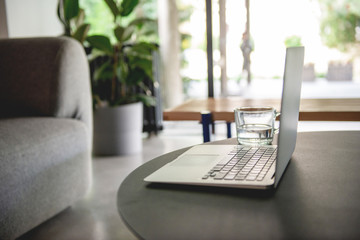 Mockup laptop comfortable work table and office supplies in office