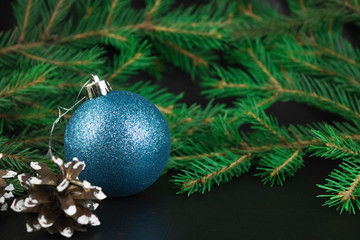 Obraz na płótnie Canvas Christmas composition. Christmas ball, cone, festive decoration on black background.