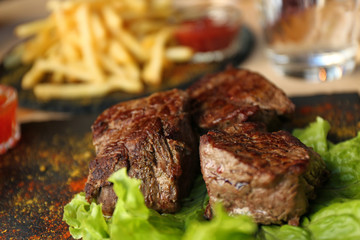 Tasty pieces of shish kebab served on slate plate in cafe