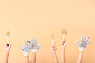 Female hands with paint brushes on color background