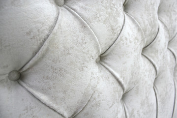 Detail of classic furniture, selective focus. Close-up of the headboard. Beige soft fabric...