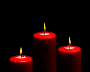 red candle on a black background.christmas candle background