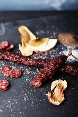 sausage with mushrooms and spices on black background, top view