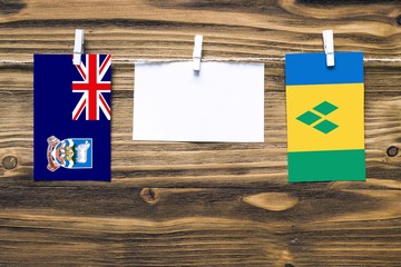 Hanging flags of Falkland Islands and Saint Vincent And The Grenadines attached to rope with...