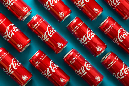 Close-up of Coca Cola drink jars lying on paper background.  Pattern. Top view.  Lvov, Ukraine - January 23, 2018. 