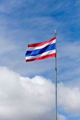 Image of waving Thai flag of Thailand with blue sky background.