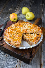 Traditional apple jalousie cake offered as closeup in a backing form on an old rustic wooden board