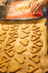 viele Plätzchen mit Herzform liegen auf einem Backblech