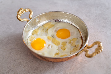 sunny side up eggs with cheese, breakfast served in copper pan