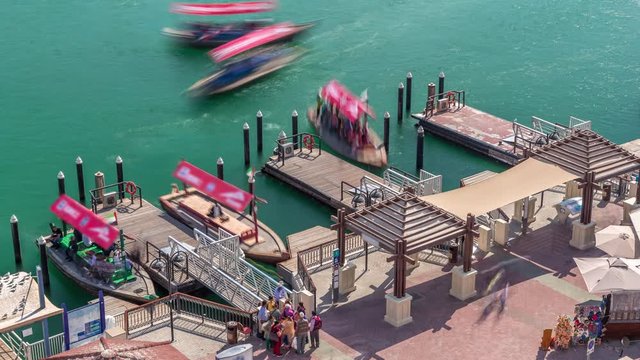 A water taxi boat station in Deira aerial timelapse. Cloudy sky and abra boats, passengers can board a Dubai Water Taxi to travel around the emirate on certain set routes.