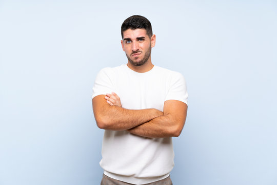 Caucasian handsome man over isolated blue background feeling upset