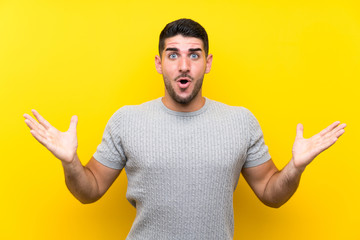Young handsome man over isolated yellow background with surprise facial expression