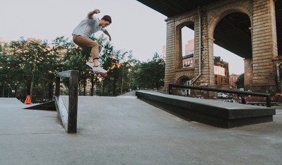 Young boy performing tricks with the skateboard in a skate park © oneinchpunch