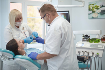 Doctor dentist treats teeth of a beautiful young girl patient. The girl on reception at the dentist. Doctor dentist treats tooth