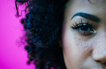 Beautiful latin woman with curly hair, portrait set in the city